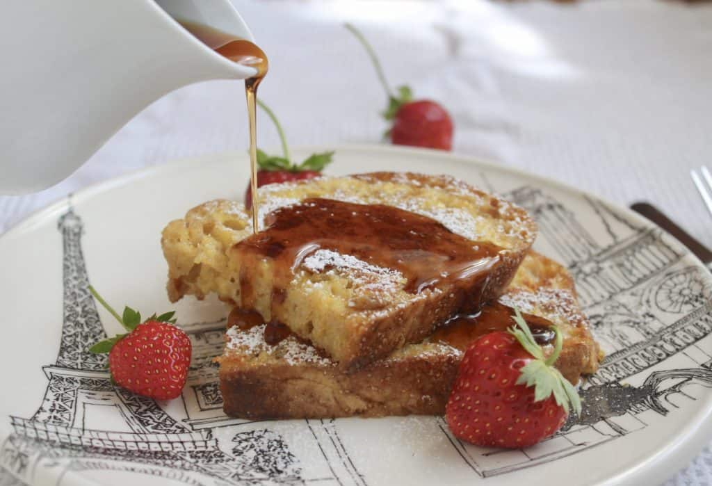 overnight French toast on plate with strawberries and syrup