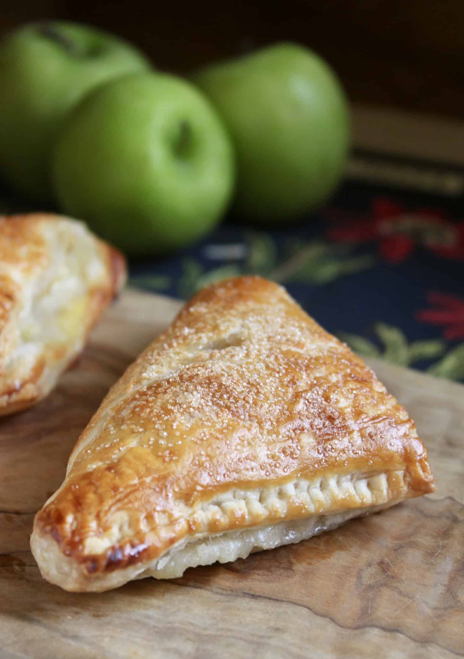 apple turnover on a board with green apples