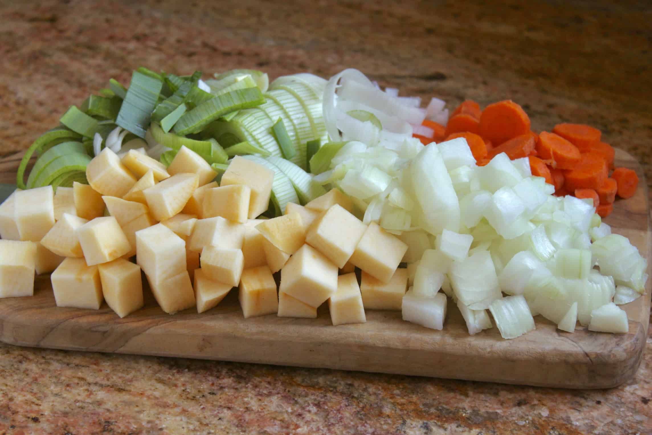 rutabaga, leeks, onion and carrots on a board