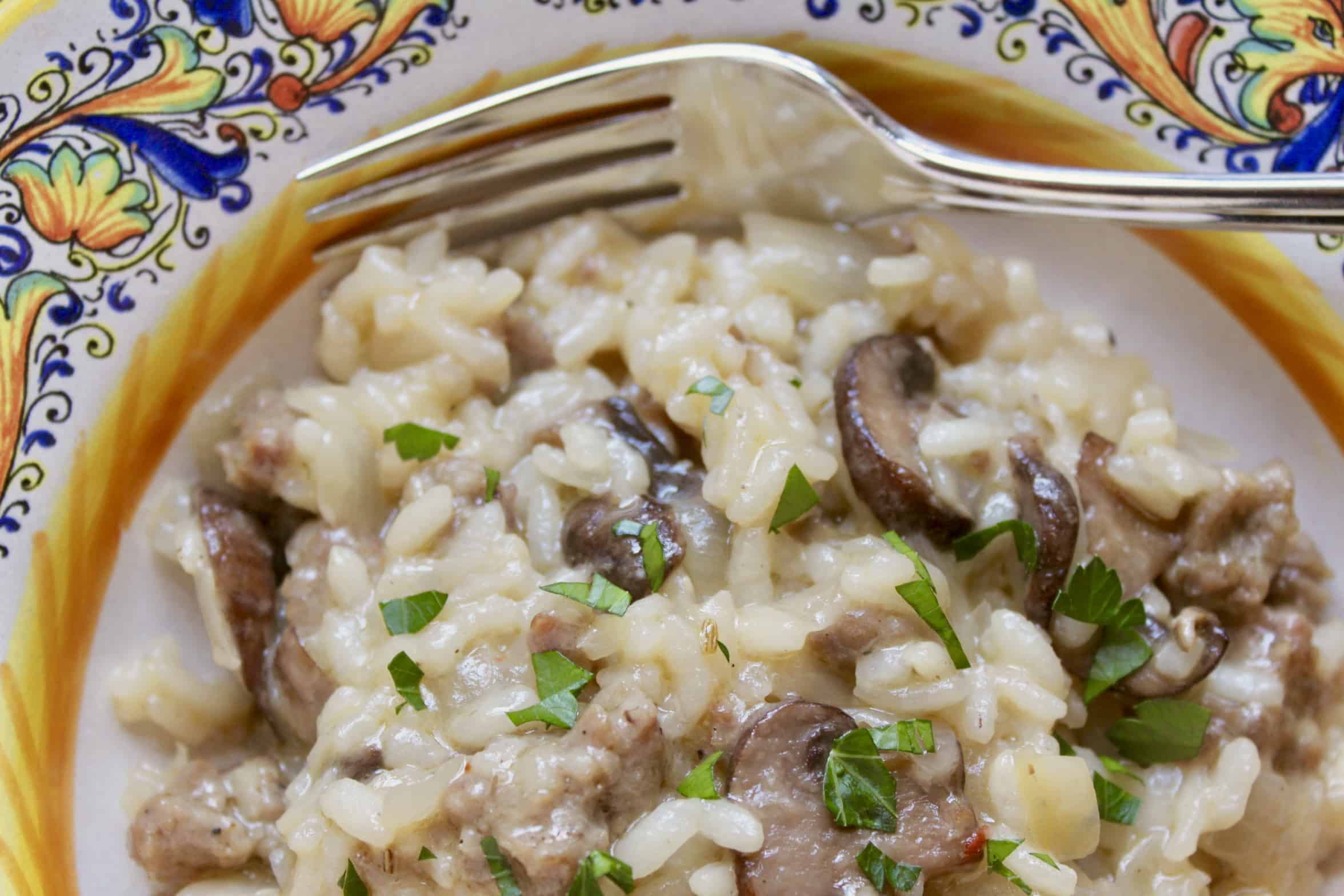 fork and sausage and mushroom risotto in a bowl
