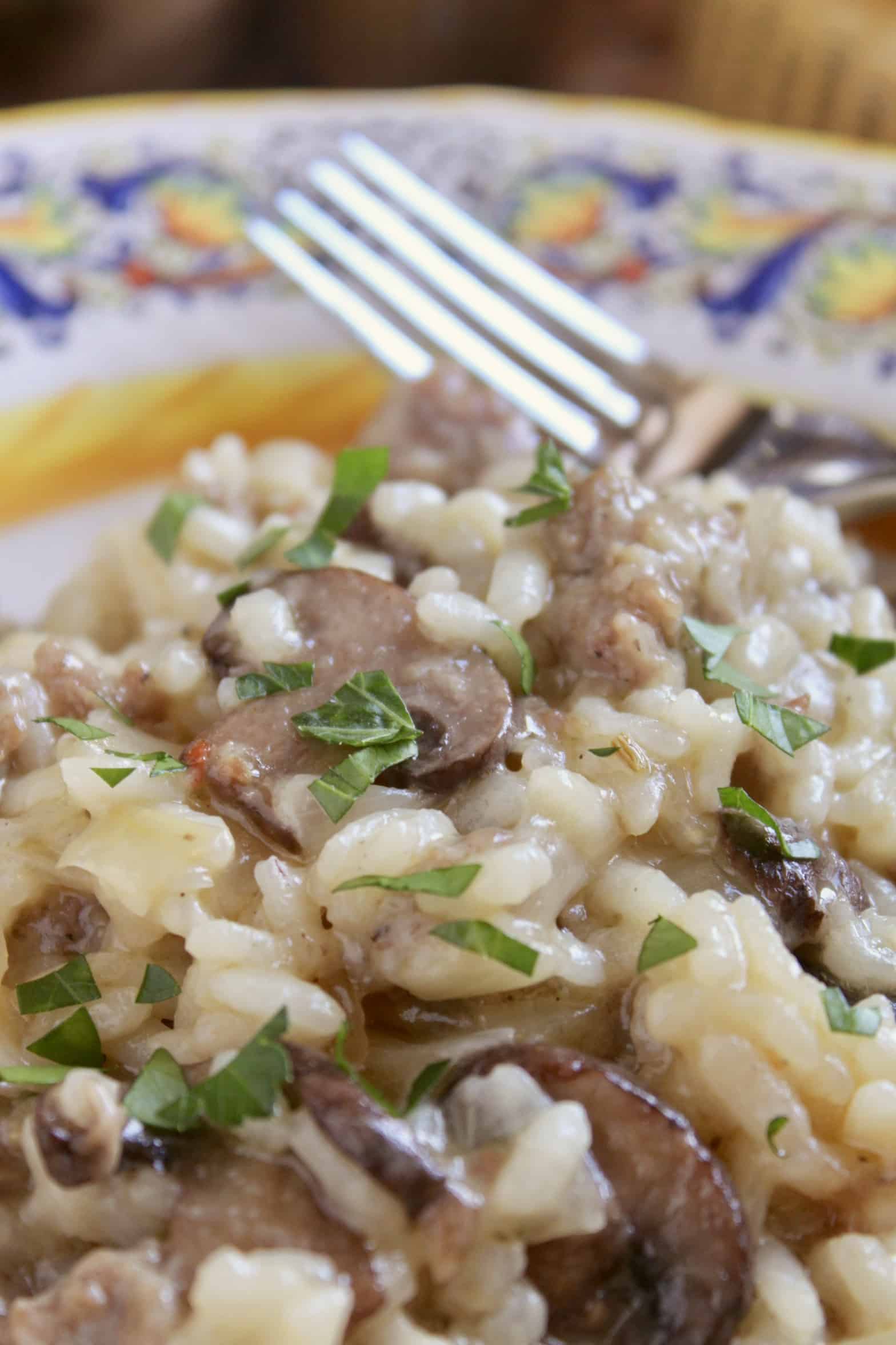 close up of sausage and mushroom risotto with fork