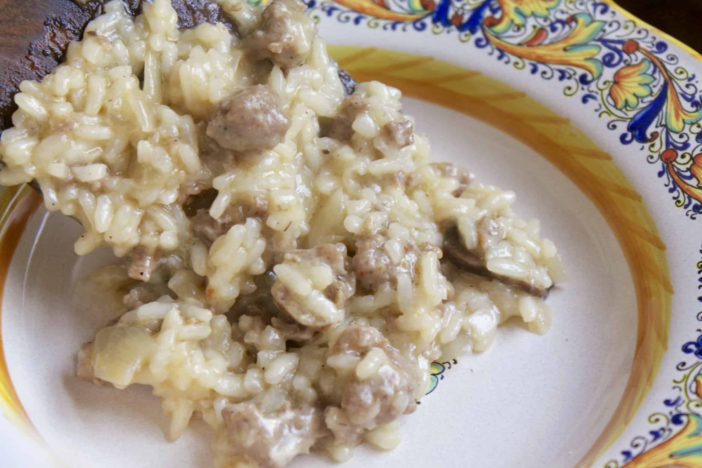 serving sausage and mushroom risotto in a bowl