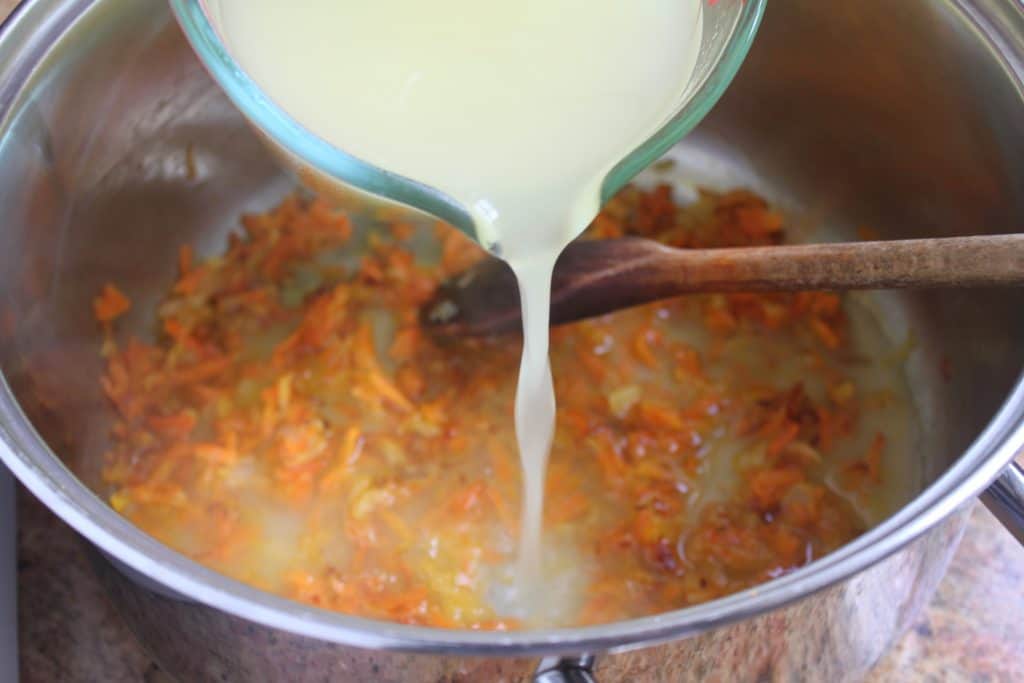 adding broth to spinach soup