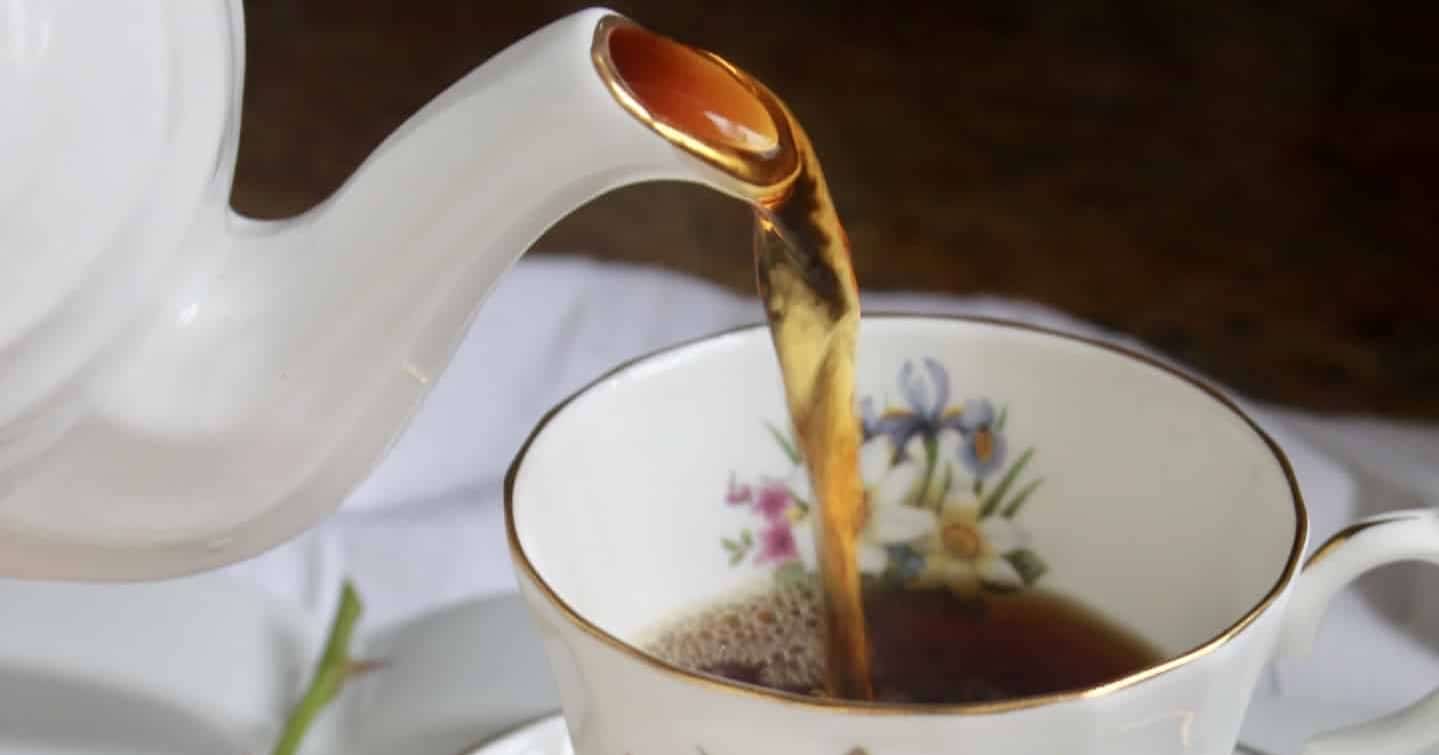 pouring a cup of tea into a pretty china cup