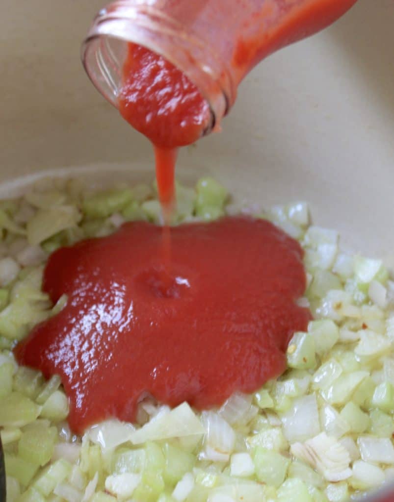 Onions and celery with tomato sauce being added