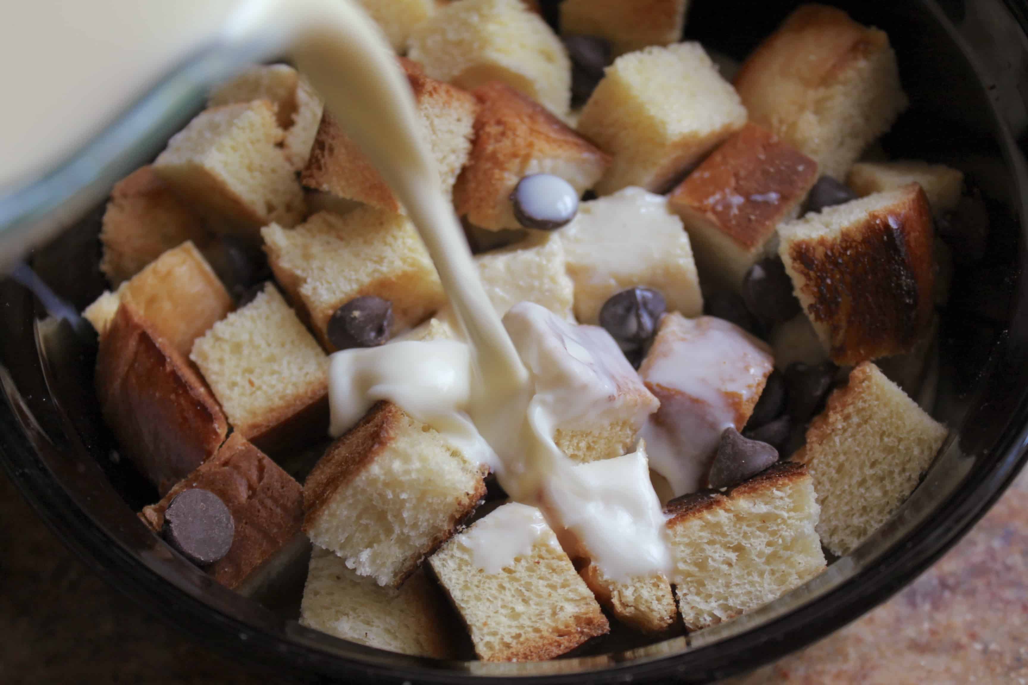 pouring milk and egg mixture to make Chocolate bread and butter pudding 