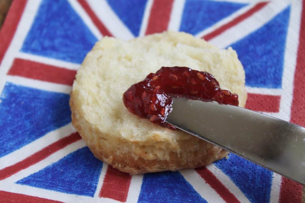 putting some jam on an afternoon tea scone