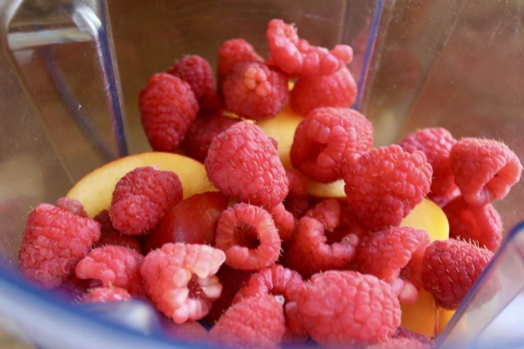 raspberries and nectarine in a blender