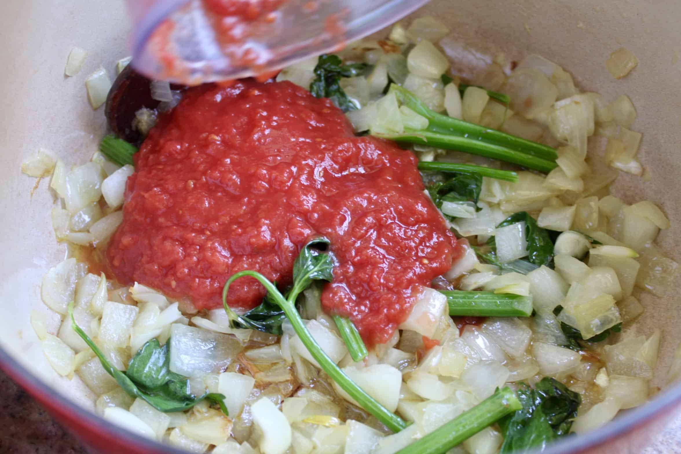adding tomato puree to onions and celery