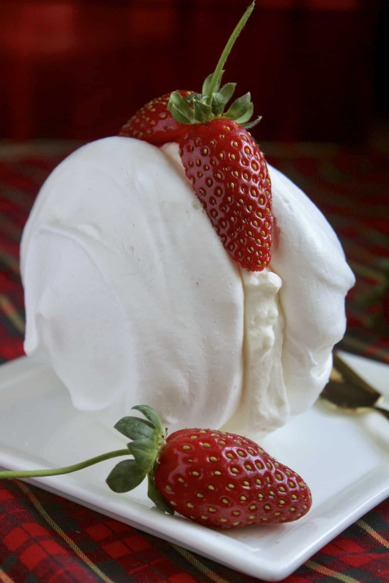 Meringues with cream and strawberries on a plate