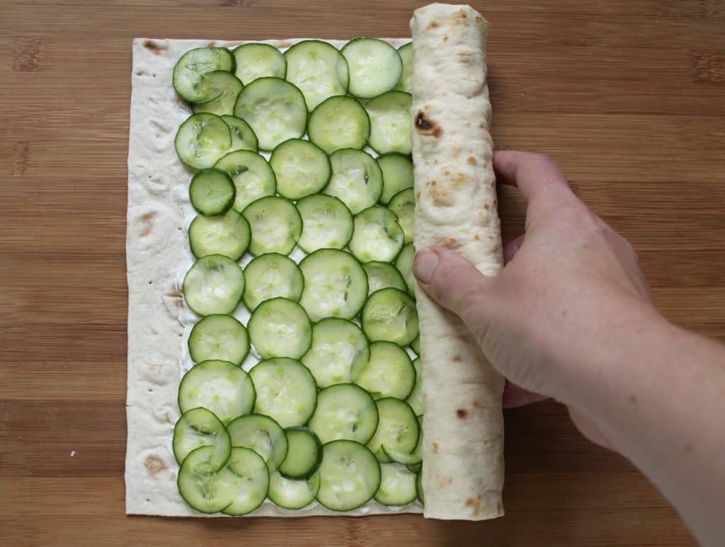 making cucumber and cream cheese sandwich rolls 