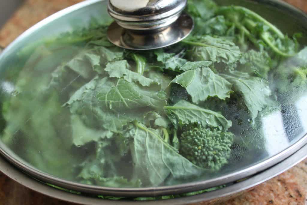 Rapini in a pan with glass lid