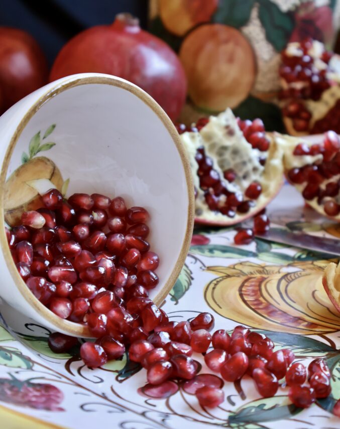 pomegranate arils spilling from bowl