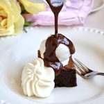 pouring chocolate over ice cream and brownie