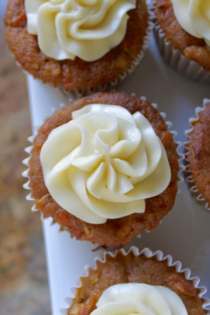 pumpkin muffins with cream cheese frosting on a cake stand