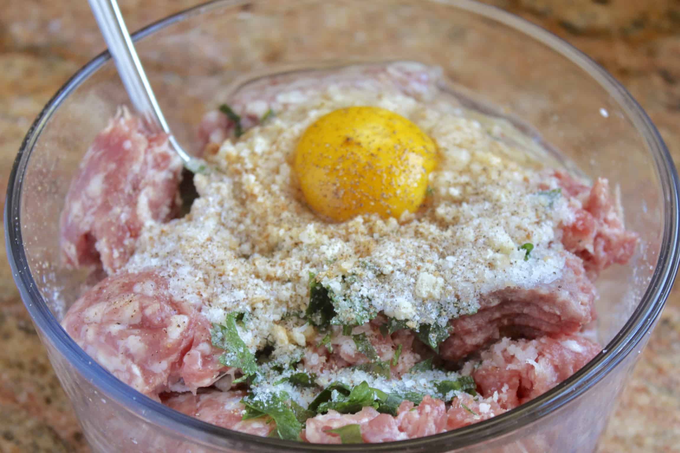 ingredients in a bowl to make meatballs, italian meatballs