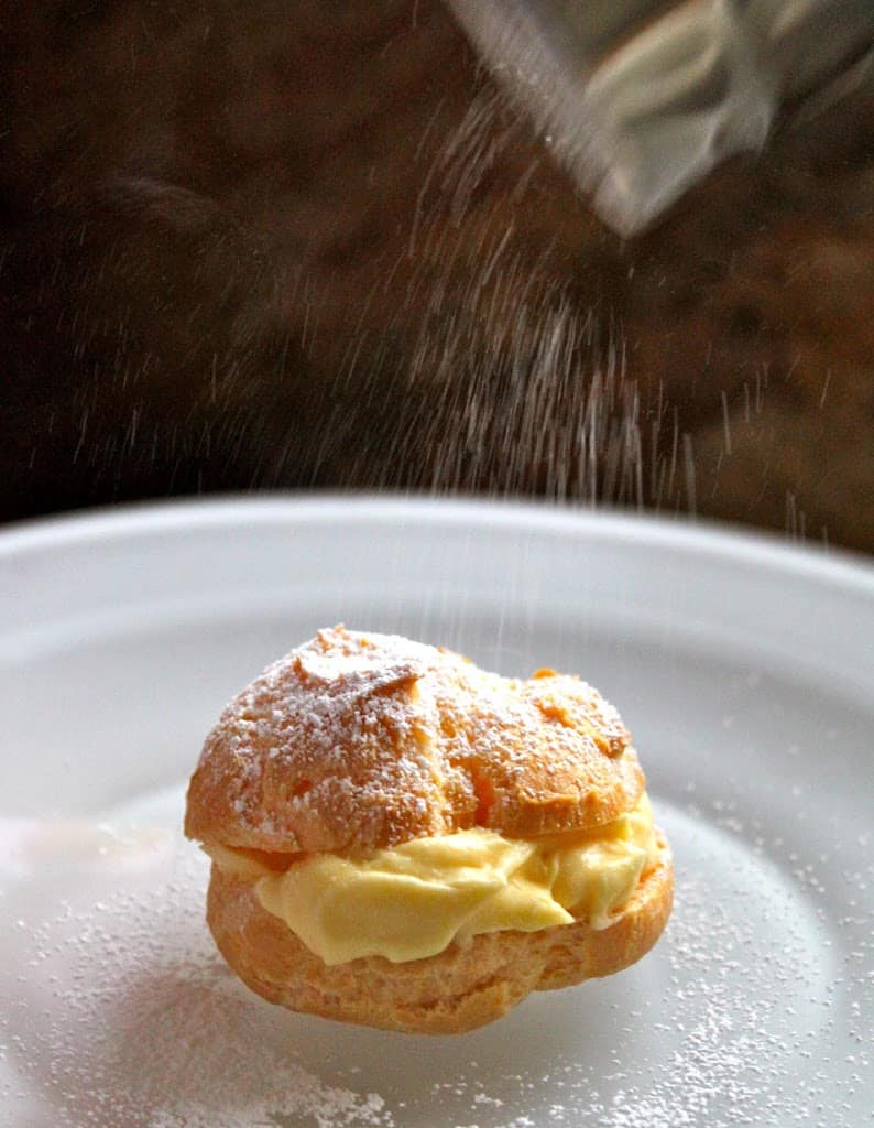 dusting profiterole cream puffs finger food