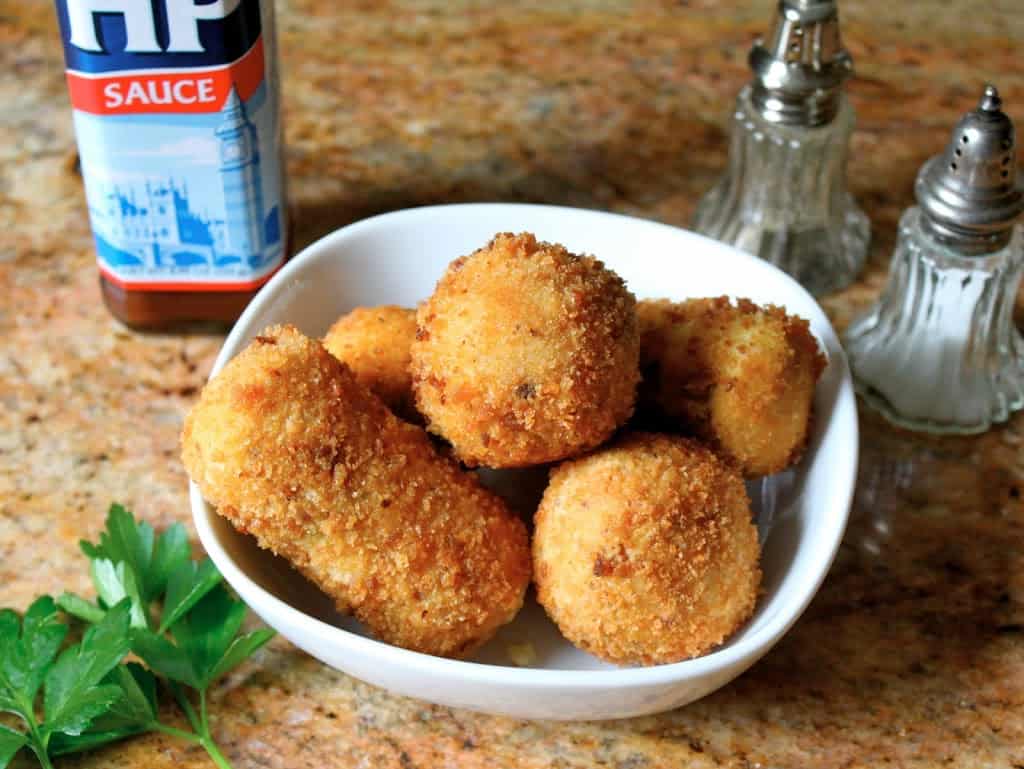 Potato Croquettes in a bowl with HP Sauce and salt and pepper