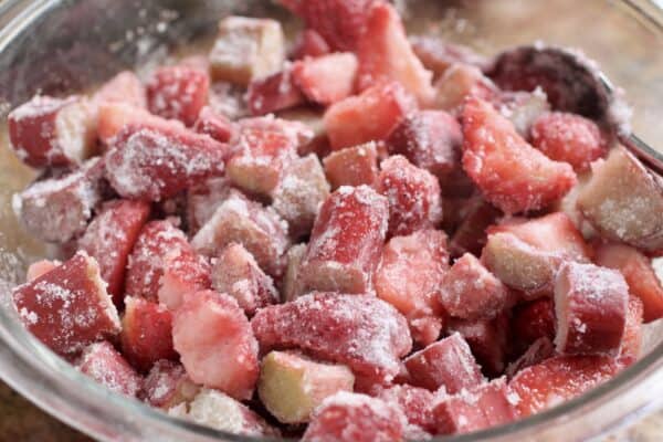 tossing strawberries and rhubarb in cornstarch and sugar