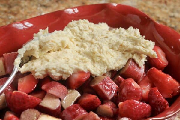 adding cobbler topping to strawberry rhubarb filling