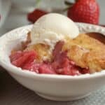 strawberry rhubarb cobbler in a bowl with ice cream