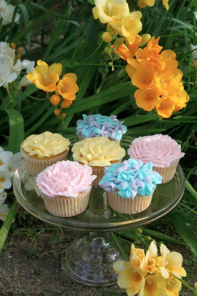Spring flower cupcakes on a cake plate with freesia
