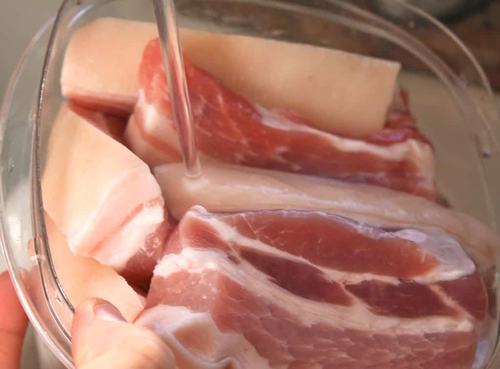 rinsing pork belly pieces