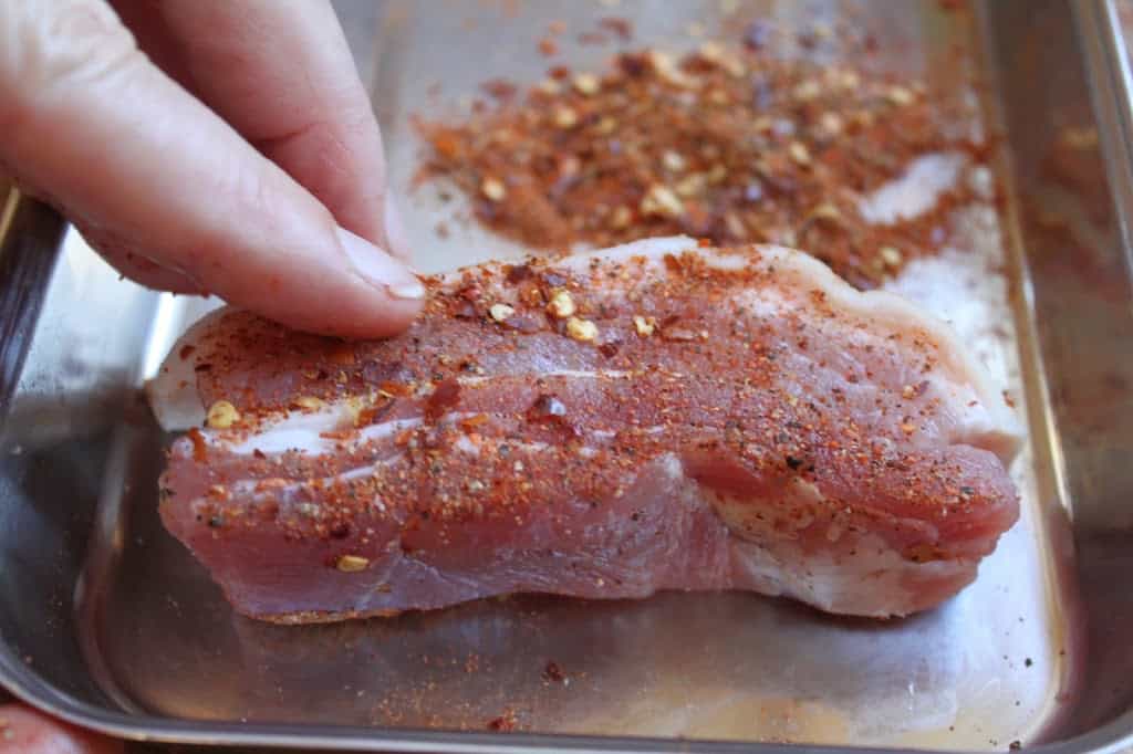 adding pepper to the pork belly