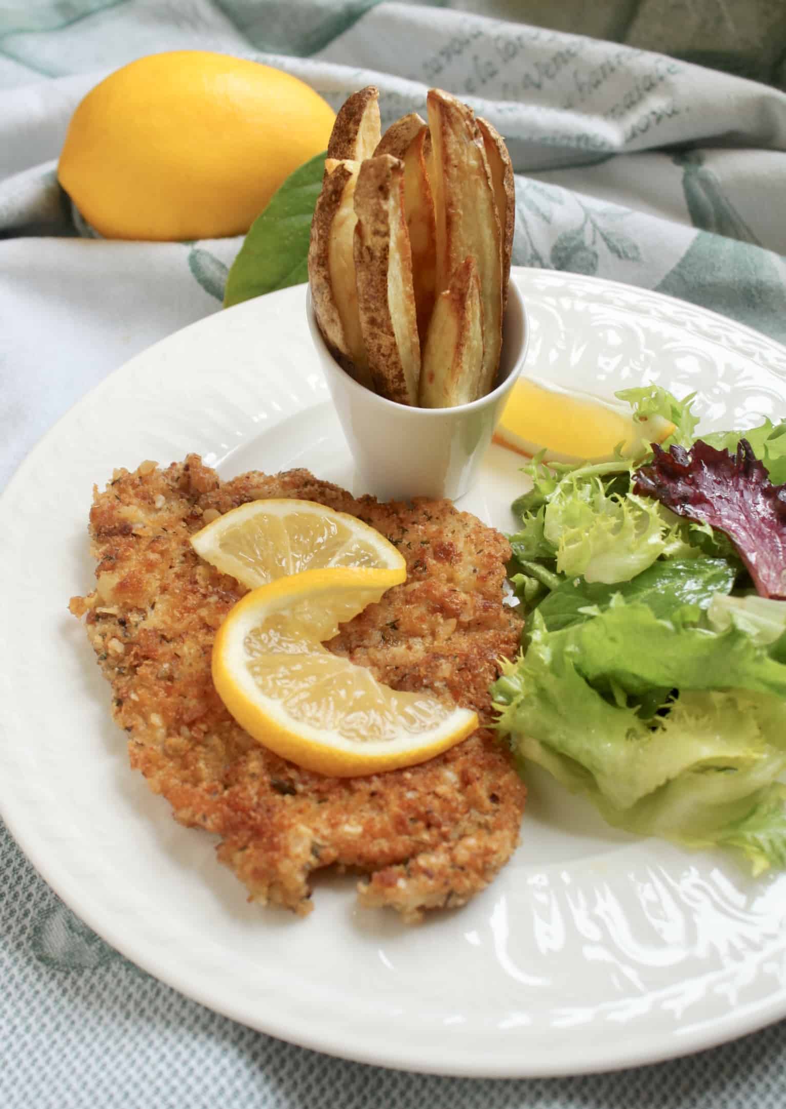 breaded pork chops on a plate with lemon