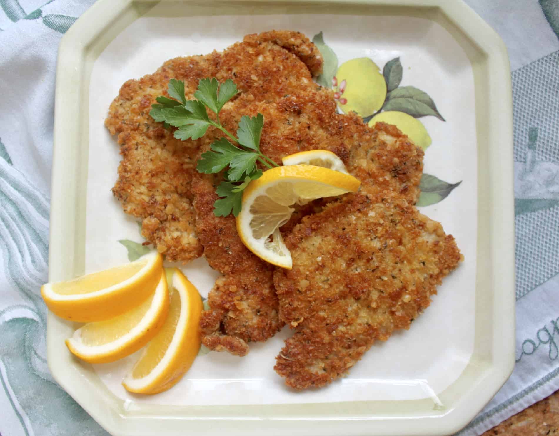 breaded pork schnitzel on a plate with lemon slices