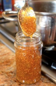pouring hot fig jam into a jar