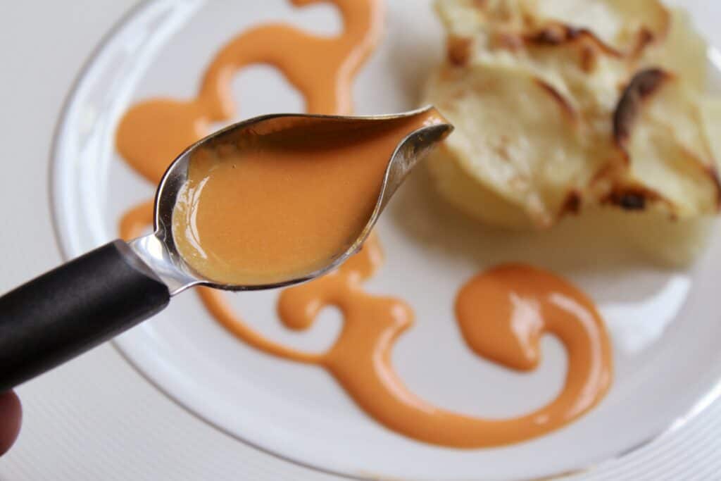 red bell pepper butter sauce with culinary spoon