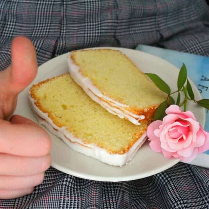 two slices of lemon pound cake on a plate with a rose on a lap