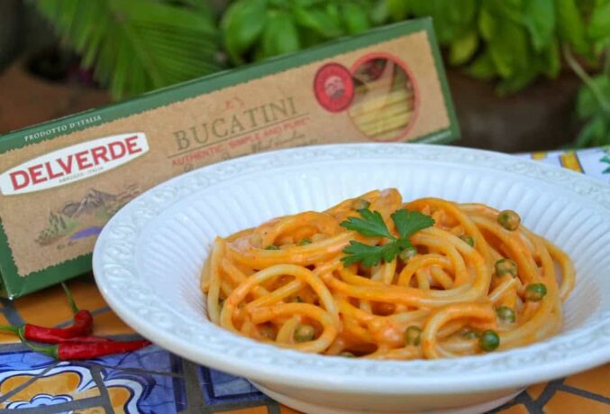 bucatini pasta with red pepper sauce and peas 