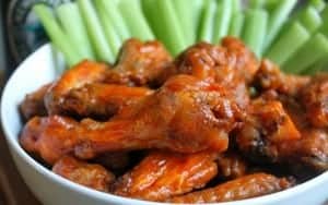 No fry buffalo hot wings with celery in a bowl
