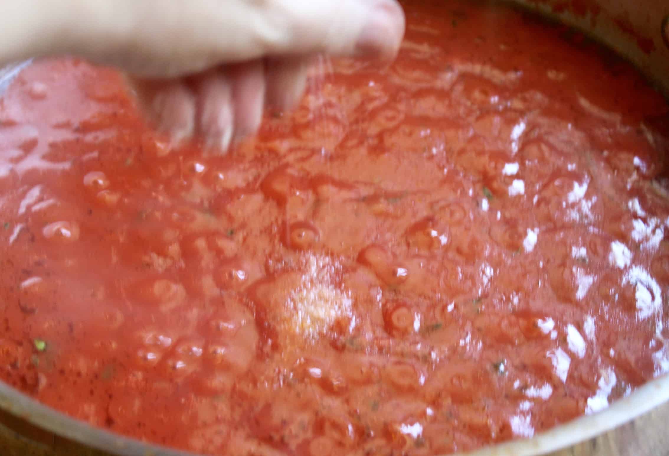 adding salt to italian tomato sauce