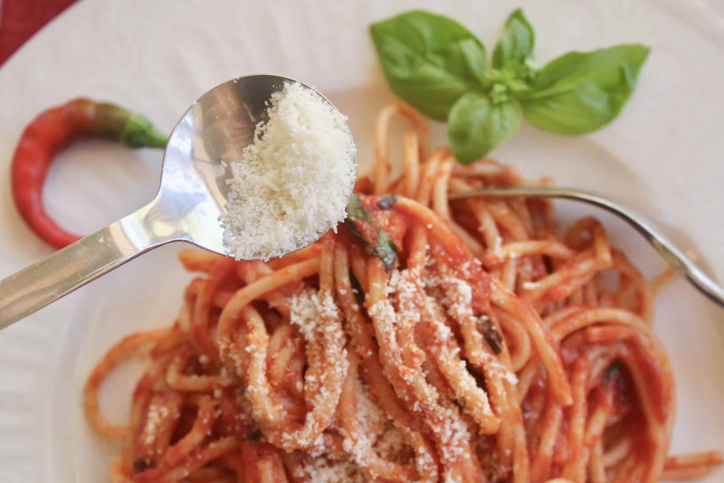 adding Parmesan to spaghetti