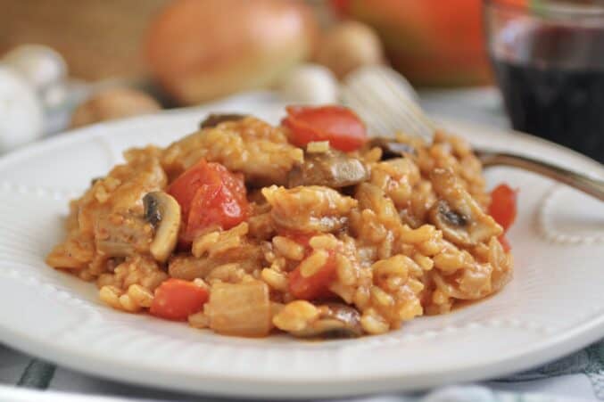 Mediterranean chicken recipe taken on a plate with veg in background