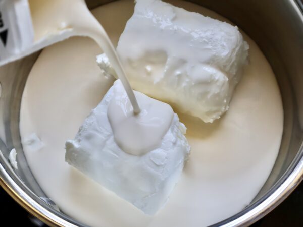 adding cream to pot with cheese
