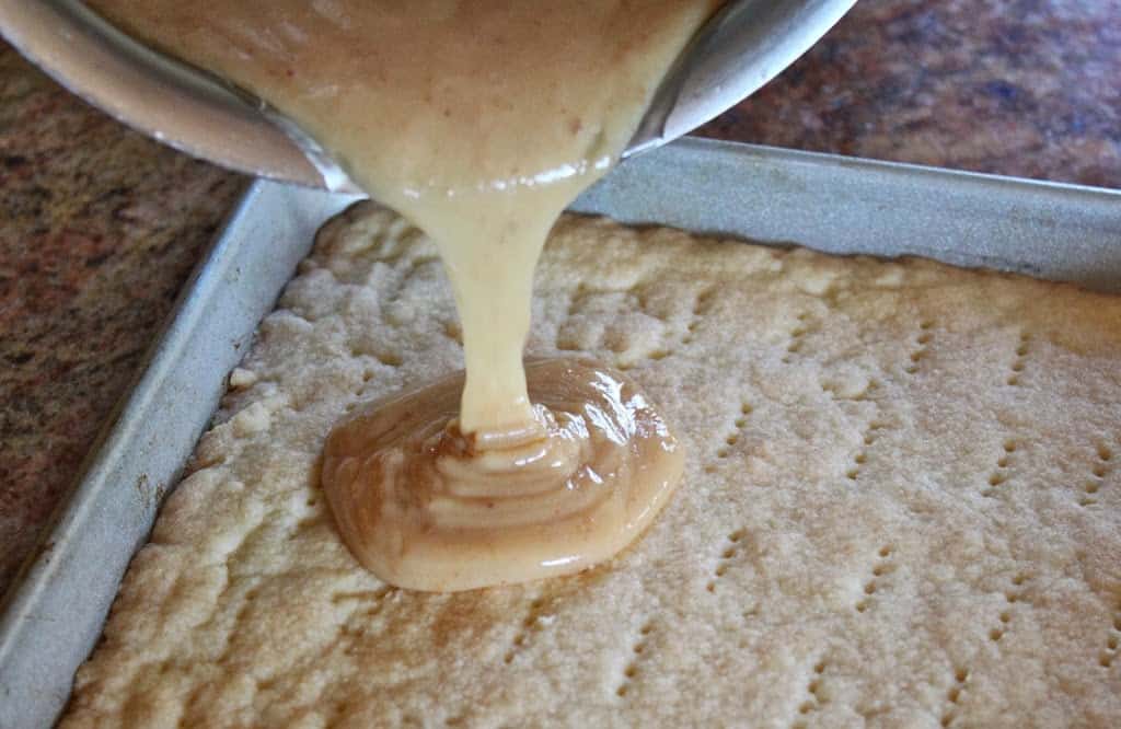 Pouring caramel onto authentic millionaire's shortbread