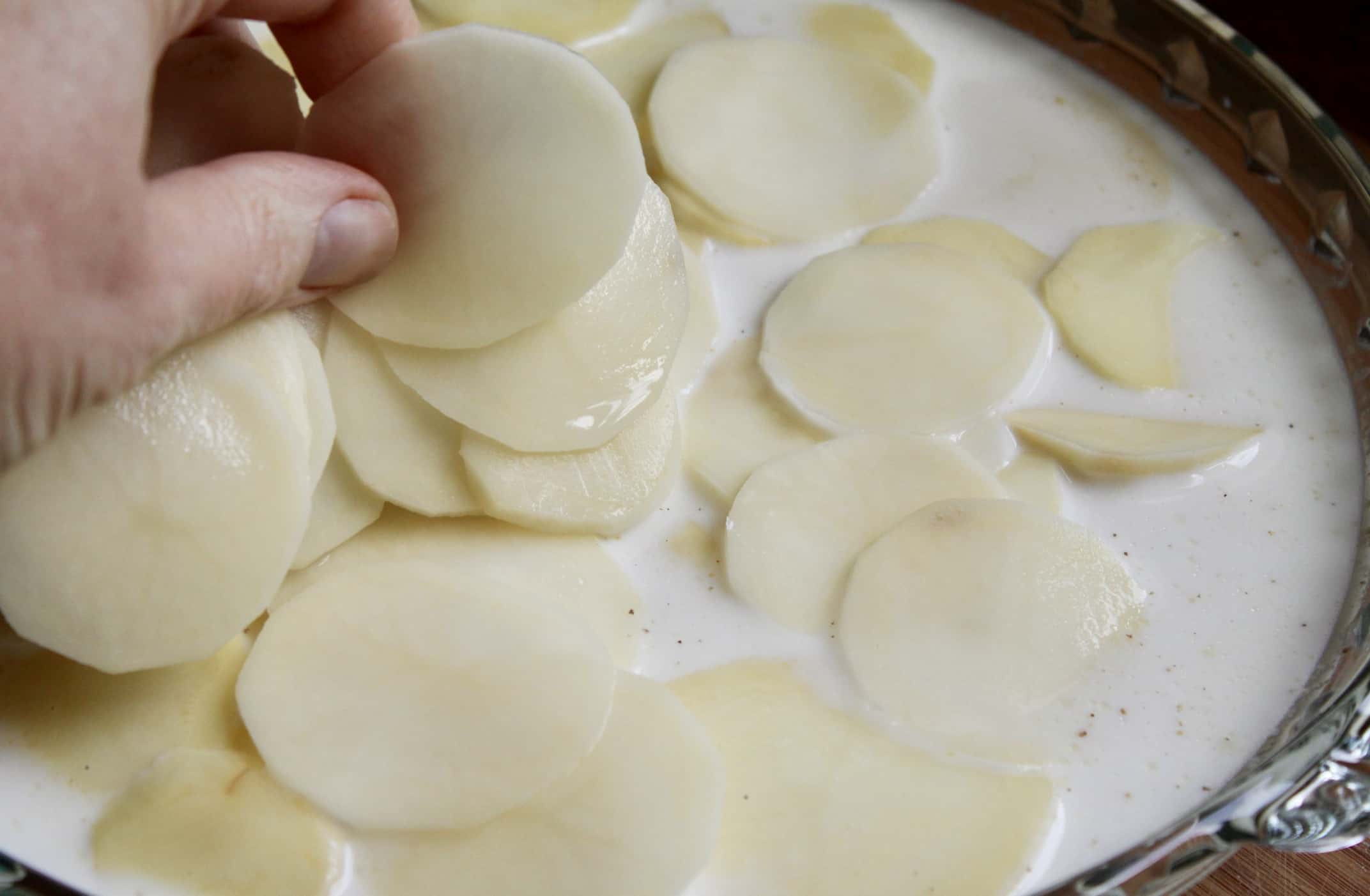 adding potato slices to milk