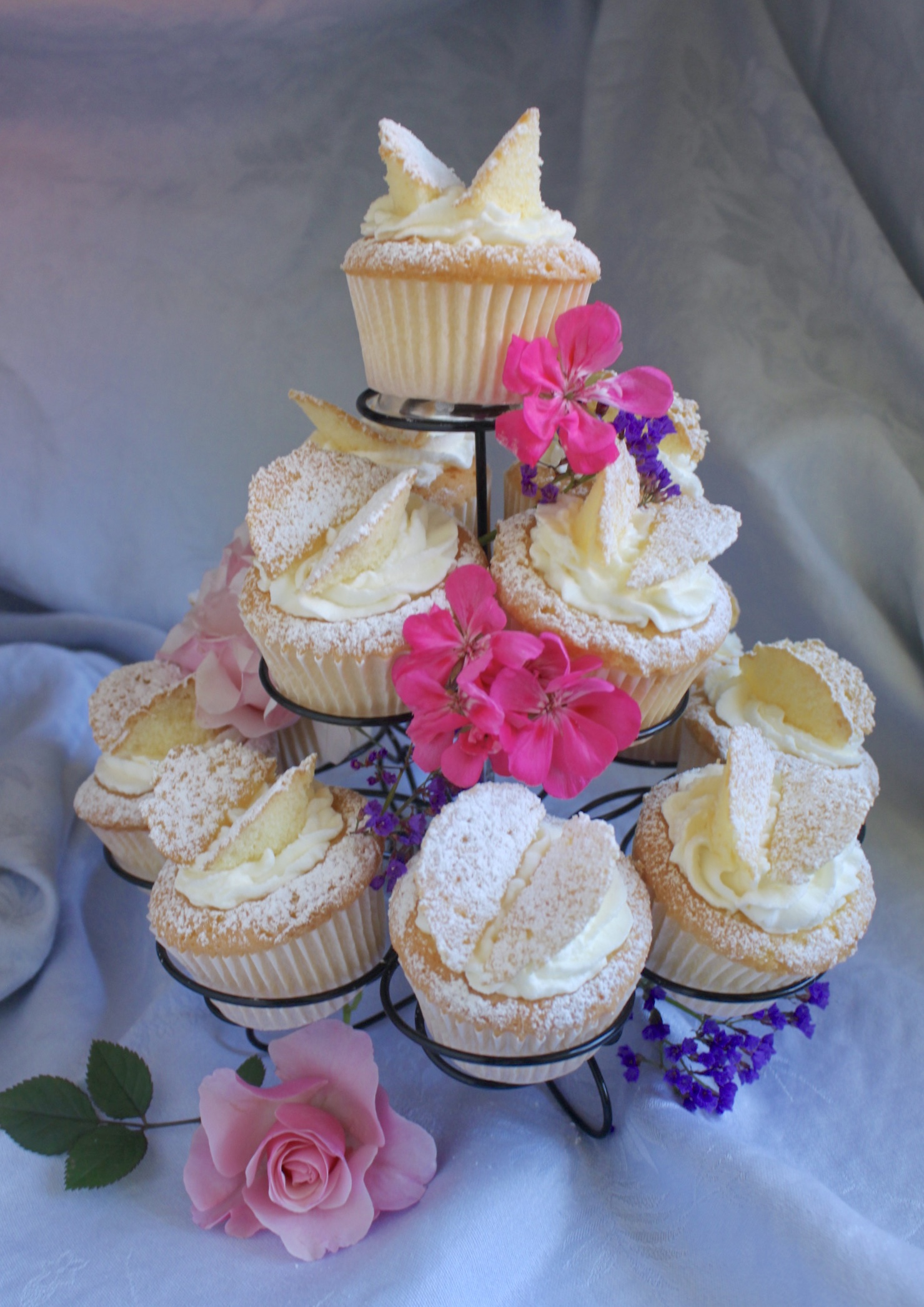 butterfly cupcakes on a stand with fresh flowers