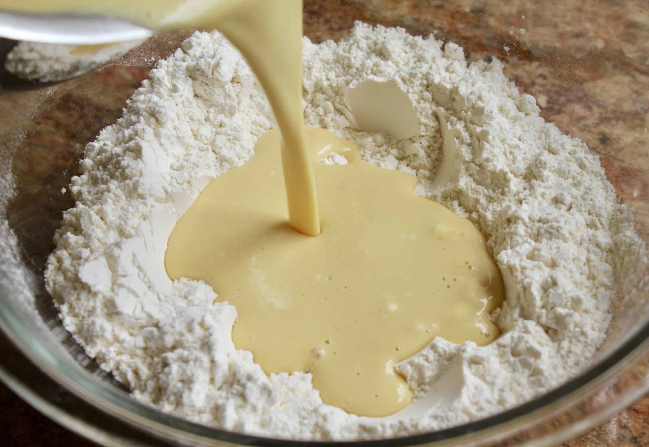 adding liquid to flour for pancakes