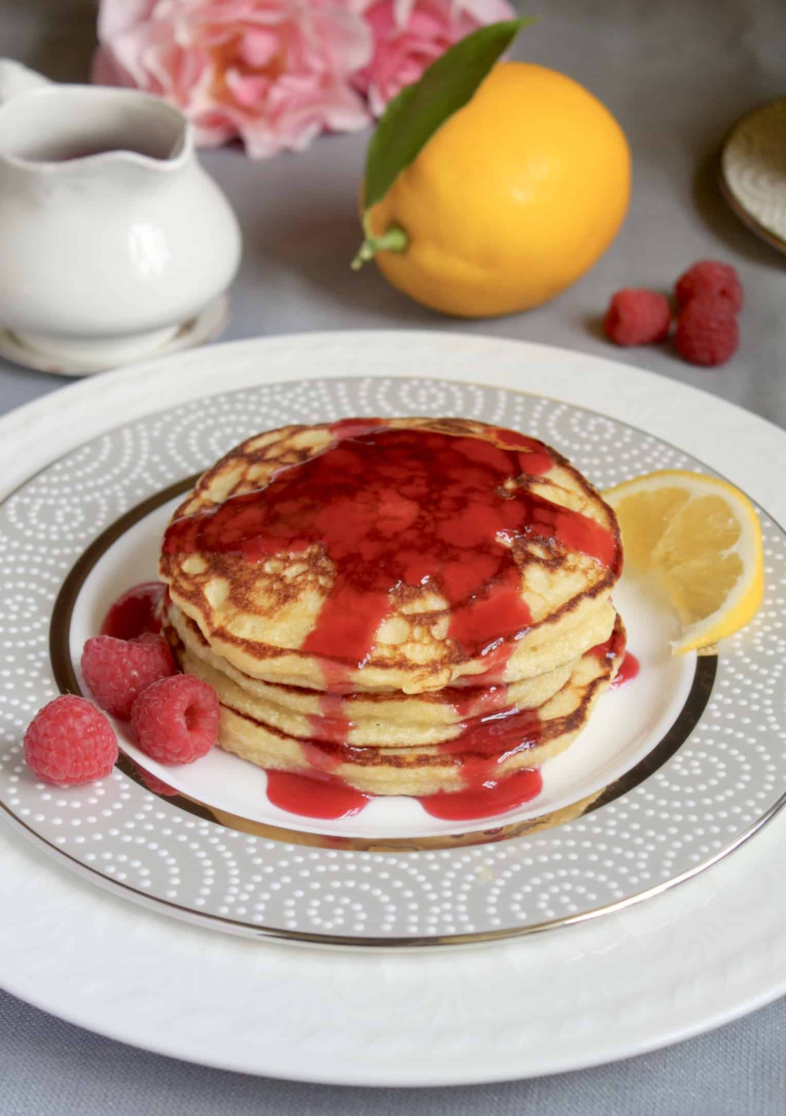 ricotta pancakes on china with lemon and pink roses