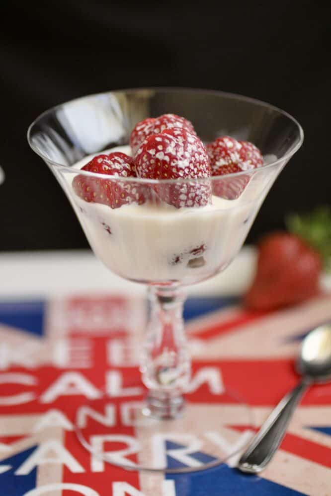 strawberries and cream in glass on tray