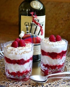 scottish dessert with whisky, honey oats and raspberries in glasses