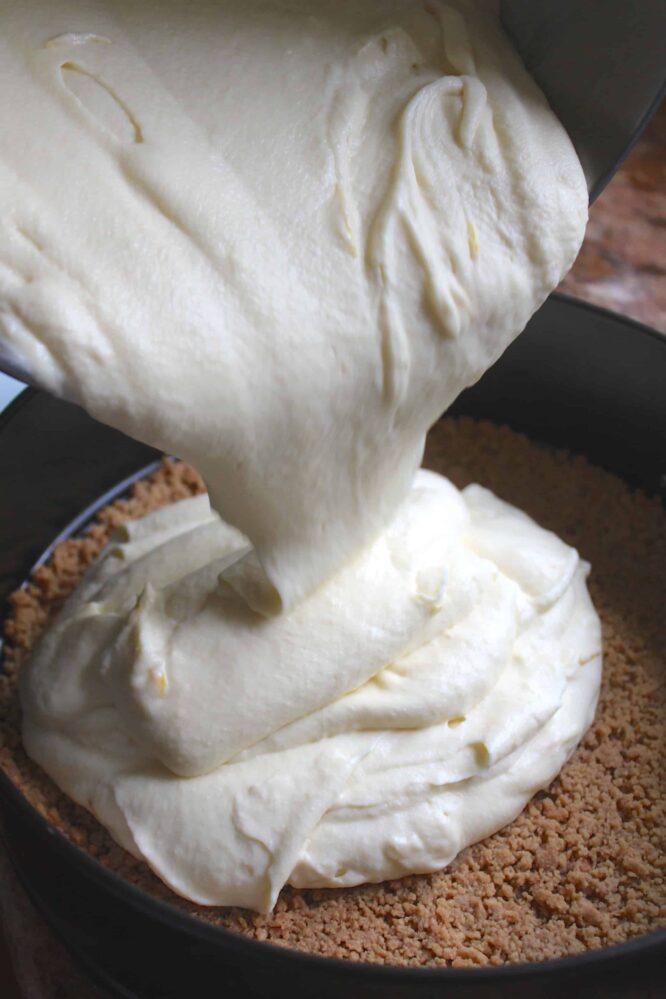 Pouring filling into cheesecake base.