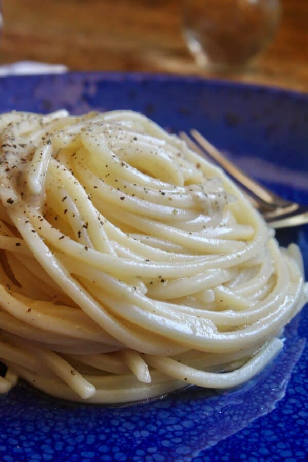 cacio e pepe pasta on a blue plate