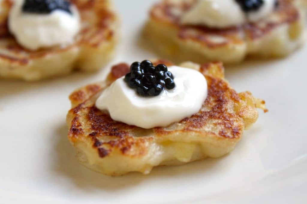 miniature Irish Boxty appetizers with creme fraiche and truffle "caviar"