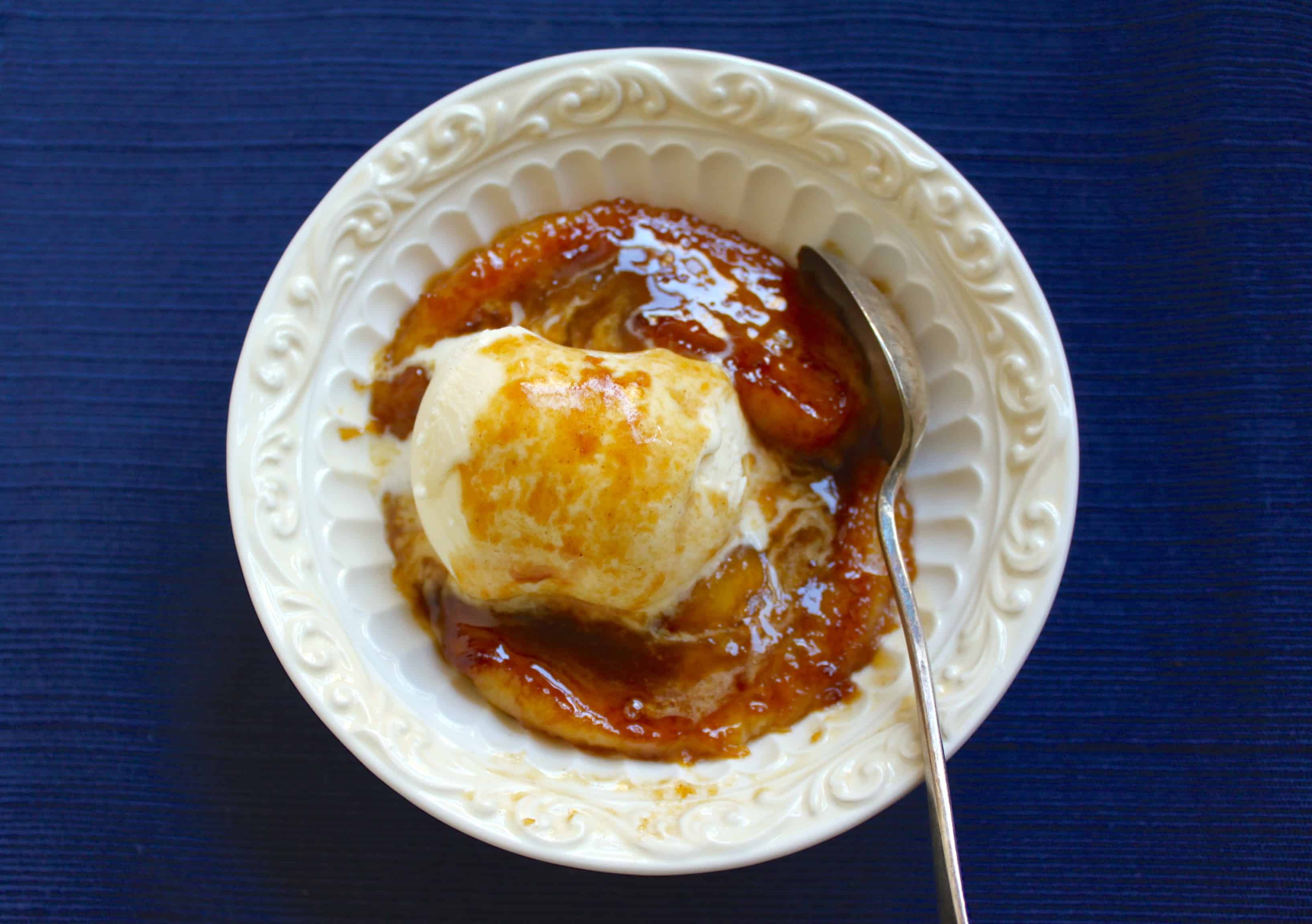 caramelized rum bananas in a bowl with ice cream